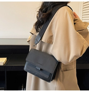 Detail view of the black matte square crossbody bag with its wide nylon shoulder strap