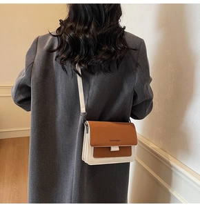 Detail of color-block flap crossbody bag featuring Fashion & Bags logo on the cover