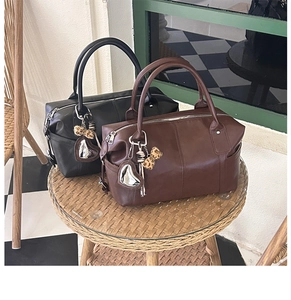 Detail of vintage Boston handbags in black and brown with heart and leopard print charms