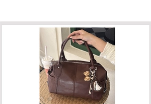 Detail of coffee brown PU leather tote with leopard bow and heart pendant on handle