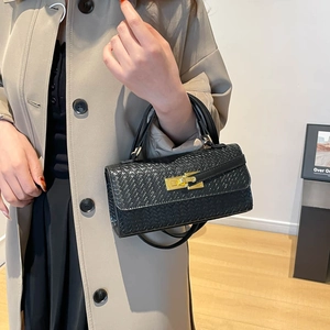 Borsa a mano in pelle intrecciata nera con chiusura dorata indossata da una modella