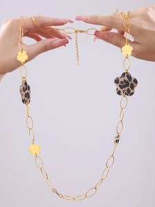 Detail of 18K gold-plated sweater necklace featuring leopard print flower charms