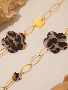 Detail of 18K gold-plated necklace featuring leopard print resin flowers and metal charms