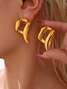 Detailed view of chunky gold twisted earrings with a polished metallic mirror finish