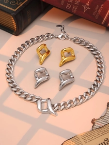 Detail of heavy metal chain necklace and abstract earrings on a retro background