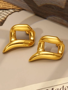 Close-up of abstract streamlined golden stud earrings with polished metallic mirror finish