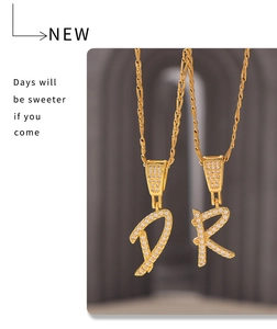 Détail de pendentifs D et R dorés avec zircons micro-pavés sur de fines chaînes
