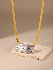 Primer plano de un collar bicolor con cadena de serpiente dorada y colgante rectangular