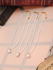 Gros plan d'un collier de perles avec grand pendentif et détail en zircone incrusté