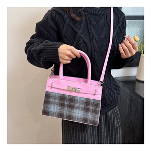 Vue détaillée du sac bandoulière en cuir rose et tissu à carreaux sur un modèle