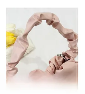 Détail de la poignée plissée du sac à main rose montrant le similicuir et l'anneau
