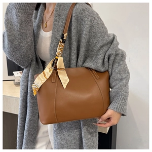 Brown leather tote bag featuring a vintage printed scarf tied to the shoulder strap