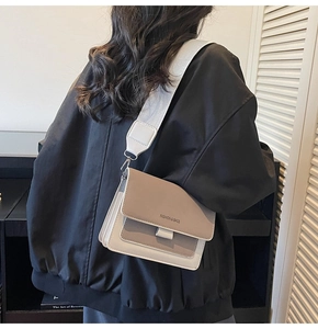 Detail of khaki and white patchwork crossbody bag with wide strap on a model