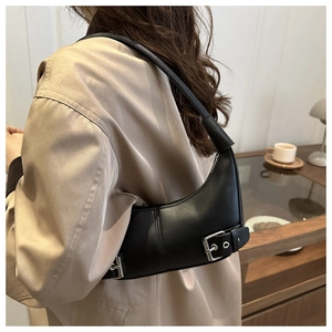 Detailansicht einer schwarzen Leder-Halbmondtasche mit silberner Schnalle am Modell