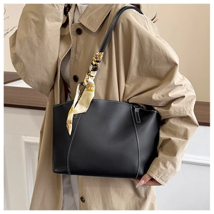 Close-up of black PU tote bag with white contrast stitching and floral silk scarf detail