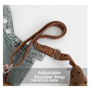 Détail de la bandoulière réglable avec boucle argentée sur un sac en velours côtelé