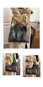 Detail view of large leopard print tote bag with black leather handles and wide strap