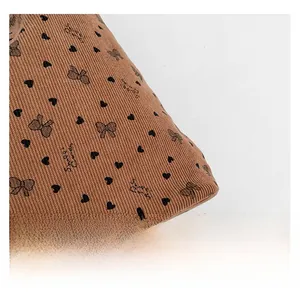 Détail du tissu en velours côtelé marron avec motifs cœurs, nœuds et texte Sweet Candy