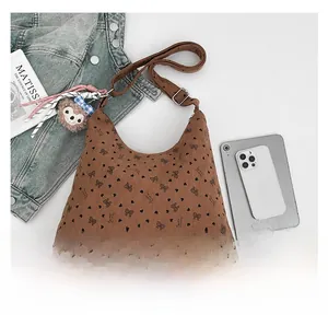 Détail du sac en velours côtelé marron avec motifs de cœurs et breloque en peluche