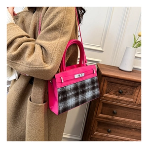Détail du sac fuchsia à carreaux avec fermoir rotatif en métal et poignée en cuir
