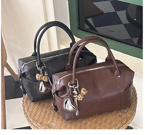 Detail of vintage Boston handbags in black and brown with heart charms and leopard pompons
