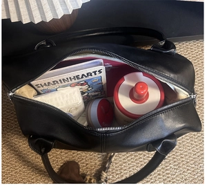 Top view of spacious black matte tote bag interior showing laptop and daily essentials