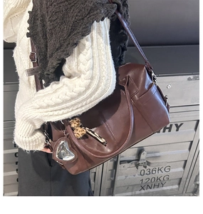 Chocolate brown leather tote bag with silver heart charm shown in retro autumn setting