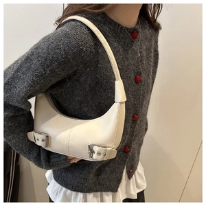 Detailansicht der cremefarbenen Hobo-Tasche mit Silberschnallen zum Casual-Outfit