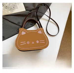 Comparaison de taille détaillée du sac bandoulière chat en cuir marron avec un smartphone