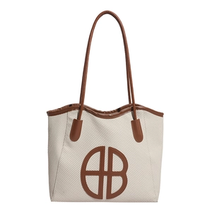 Modern beige woven tote bag with brown leather trim and prominent B-logo design