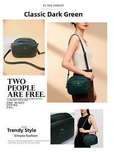Sac bandoulière vert foncé en similicuir avec trois compartiments zippés et logo métal