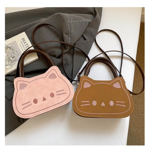 Détails de broderie chat et texture suédine sur ce petit sac rose en bandoulière