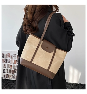 Detail of vintage tote bag featuring beige canvas and brown leather contrast stitching