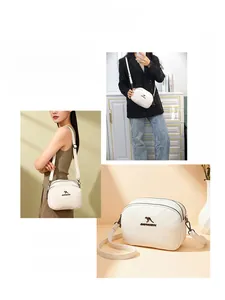 Détail du sac coquille en cuir PU blanc avec logo kangourou doré et fermeture éclair