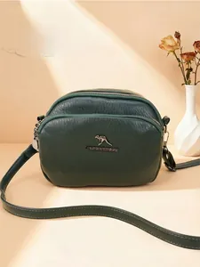 Détail du sac à bandoulière vert foncé avec texture litchi et double fermeture éclair
