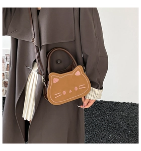Détail de la broderie de chat sur un sac bandoulière en similicuir marron avec anse