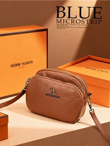 Détail du sac bandoulière marron en cuir avec double fermeture éclair et logo métal