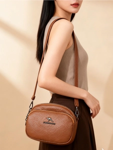 Détail du sac bandoulière marron en cuir PU texturé avec logo kangourou en métal