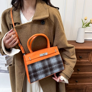 Sac à main chic en cuir orange et tissu à carreaux gris avec un fermoir rotatif argenté