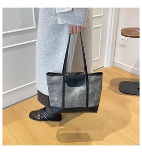 Detailed side view of the grey marble pattern tote bag with black trim and snap closure