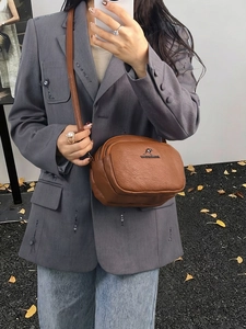 Détail du petit sac bandoulière en similicuir marron avec texture litchi et trois zips