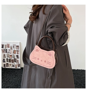 Mini sac chat rose avec broderies, porté par un mannequin en manteau gris chic