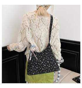 Détail du sac cabas en velours noir avec motifs cœurs et un pendentif singe en peluche