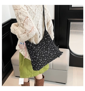 Sac bandoulière demi-lune noir avec imprimés cœurs et nœuds blancs et charm rose doux