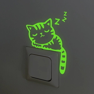 Glow-in-the-dark sleeping cat wall sticker applied on a white light switch panel