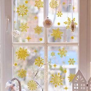 Close-up of golden glitter snowflake window stickers in various sizes for Christmas decor