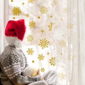 Golden snowflake static window decals applied on glass with a festive holiday atmosphere