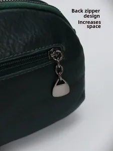Détail de la poche zippée arrière et texture grainée du sac en cuir vert foncé