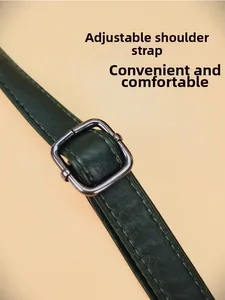 Détail de la bandoulière réglable en cuir vert foncé avec boucle métallique pour sac