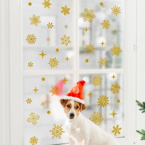 Close-up of golden glitter snowflake window stickers with stars for Christmas decor